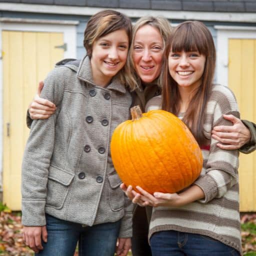Laura and her kids holding a pumpkin