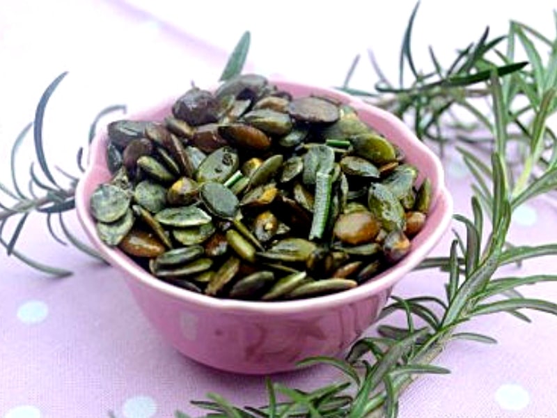 Freshly roasted pumpkin seeds with rosemary